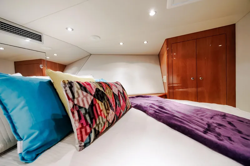 Slide: The Image of Luxurious bedroom interior of 2005 Hatteras 50 Convertible yacht with colorful pillows and wood cabinetry. - 41