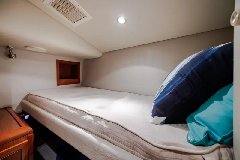 Slide: The Image of Cozy cabin bed in 2005 Hatteras 50 Convertible yacht, featuring modern lighting and plush pillows. - 45