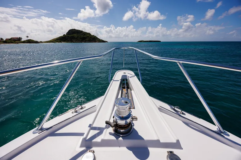Slide: The Image of Bow view of 2005 Hatteras 50 Convertible yacht cruising in clear blue waters. - 51