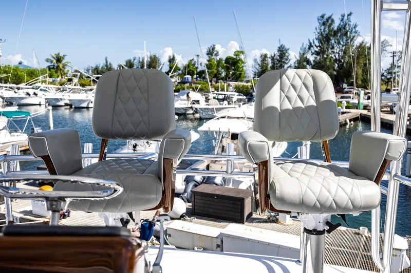 Slide: The Image of Luxury helm chairs on a 2005 Hatteras 50 Convertible yacht, docked at a marina. - 60
