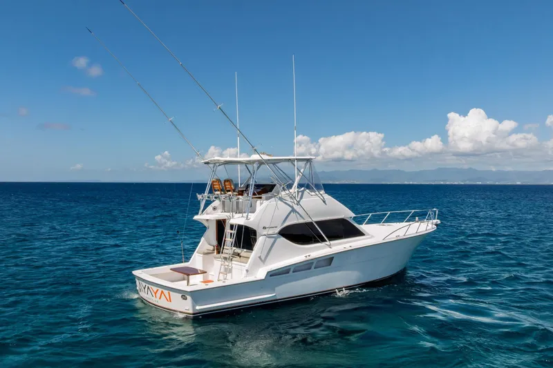 Slide: The Image of 2005 Hatteras 50 Convertible yacht on open sea under clear blue sky. - 68