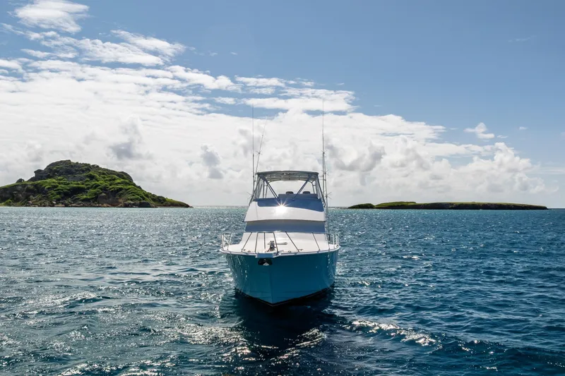 Slide: The Image of 2005 Hatteras 50 Convertible yacht cruising in clear blue ocean near islands. - 74