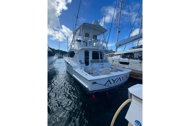 Slide: The Image of 2005 Hatteras 50 Convertible yacht docked under a clear blue sky. - 9