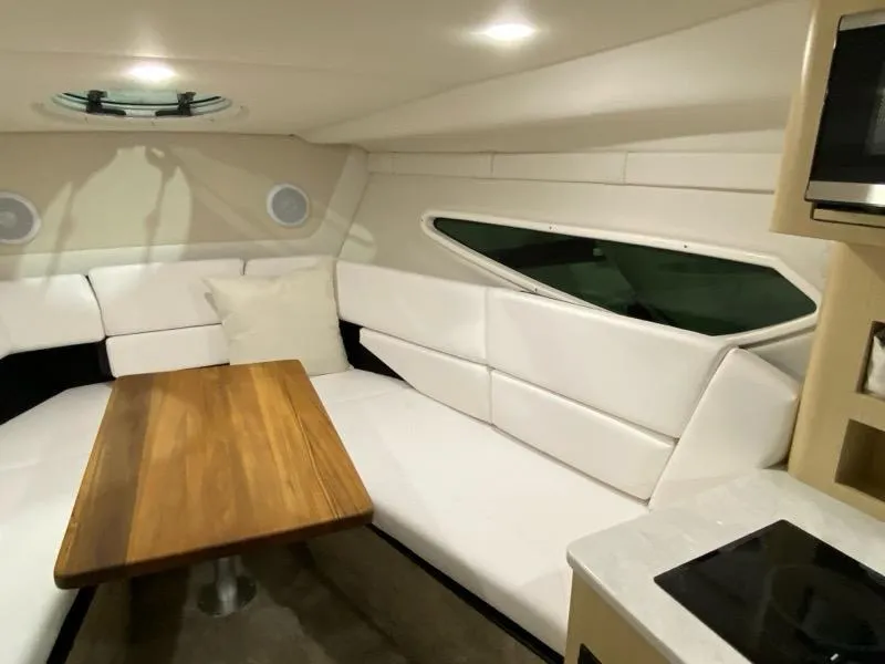 Slide: The Image of 2026 Regal 26 XO boat interior with white seating, wooden table, and modern design. - 22
