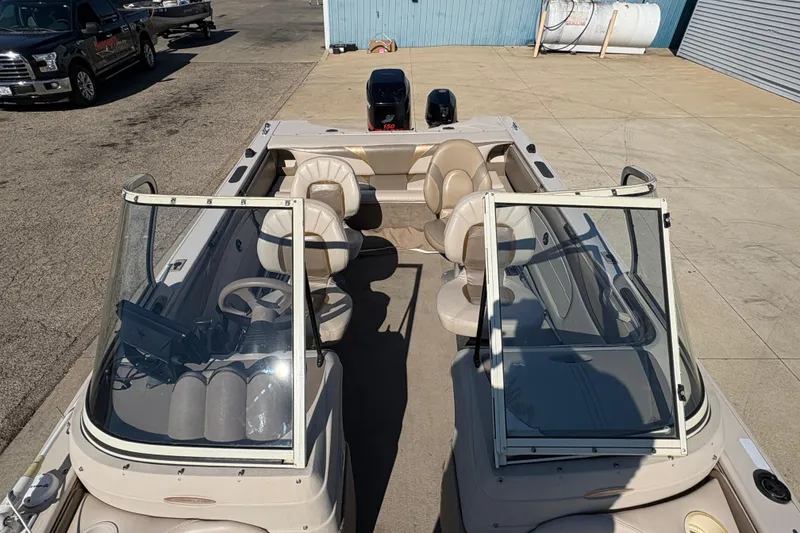 Slide: The Image of 2001 Crestliner 1900 PHANTOM SST boat with beige interior and dual windshields, parked outdoors. - 17
