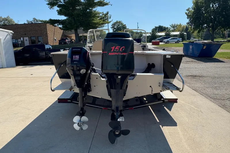 Slide: The Image of 2001 Crestliner 1900 PHANTOM SST boat with dual Mercury outboard motors in a parking lot. - 3