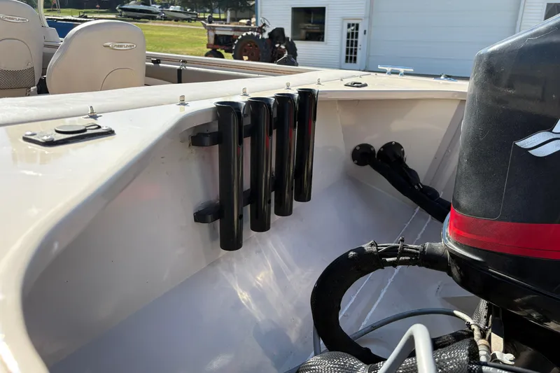 Slide: The Image of 2001 Crestliner 1900 PHANTOM SST boat interior with rod holders and motor detail. - 34