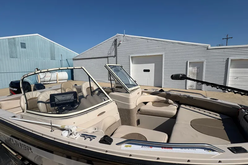 Slide: The Image of 2001 Crestliner 1900 PHANTOM SST boat with seating, electronics, and storage, parked near buildings. - 37