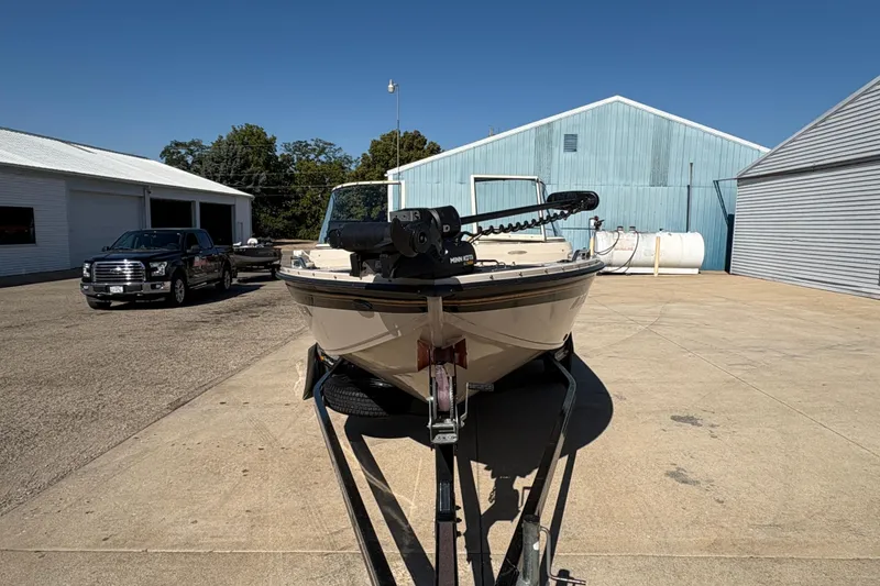 Slide: The Image of 2001 Crestliner 1900 PHANTOM SST boat on trailer, parked near industrial buildings. - 7