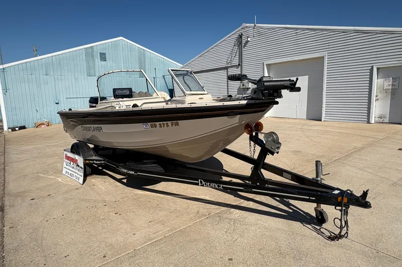 Slide: The Image of 2001 Crestliner 1900 PHANTOM SST boat on trailer, parked outside blue and white buildings. - 8