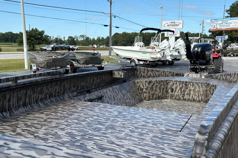 Slide: The Image of 2025 Edge Duck Boats 756DB with camouflage design, displayed outdoors with other boats. - 7