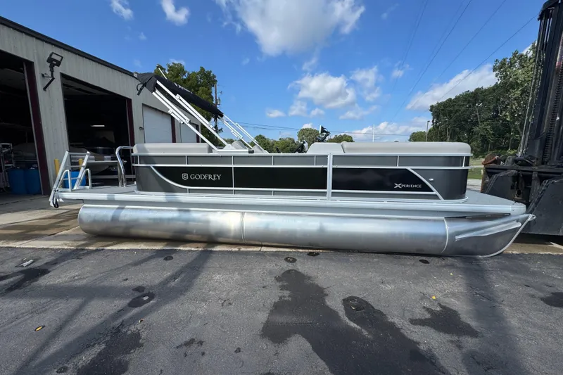 The Image of 2026 Sweetwater EX2286SBX pontoon boat docked outside under blue sky. - 0