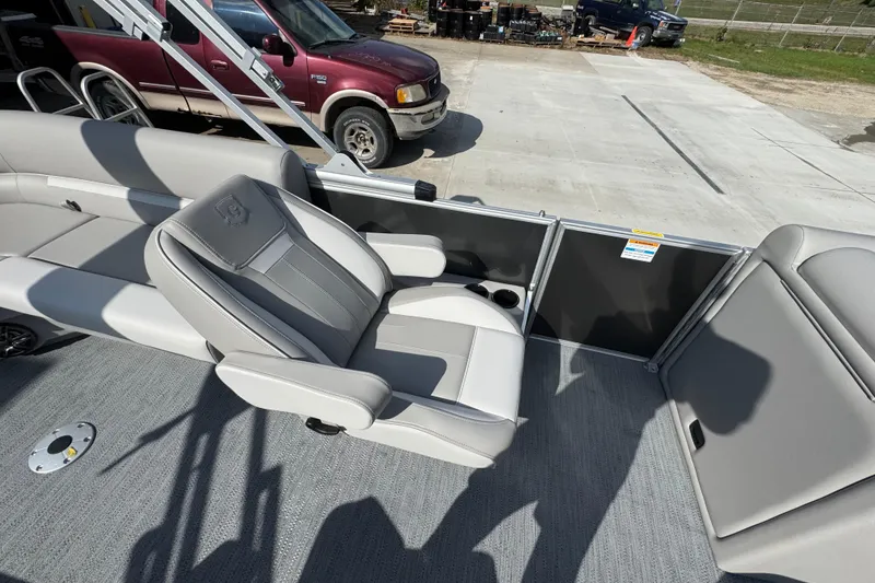 Slide: The Image of 2026 Sweetwater EX2286SBX boat interior with gray seating and cup holders. - 13