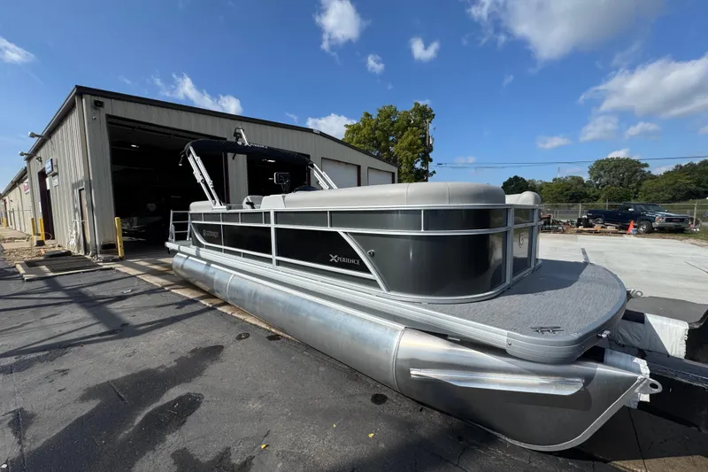 Slide: The Image of 2026 Sweetwater EX2286SBX pontoon boat outside a warehouse under a clear blue sky. - 4