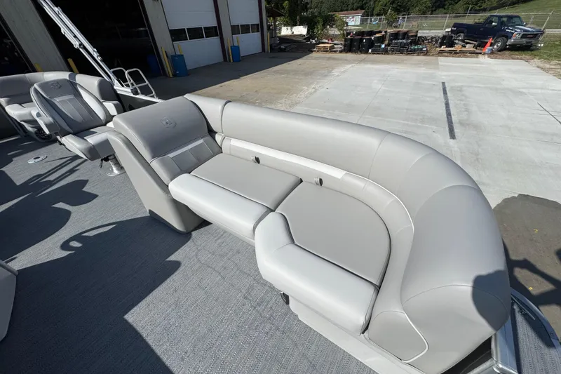 Slide: The Image of 2026 Sweetwater EX2286SBX boat with luxurious gray seating in a sunny outdoor setting. - 7