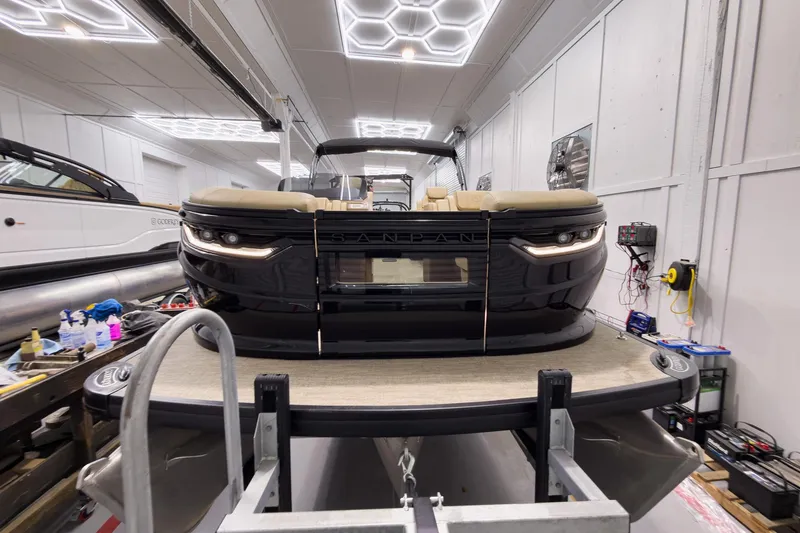 Slide: The Image of 2026 Godfrey Sanpan 23' Ultra Lounge Tritoon in a showroom, showcasing sleek design and luxury features. - 3