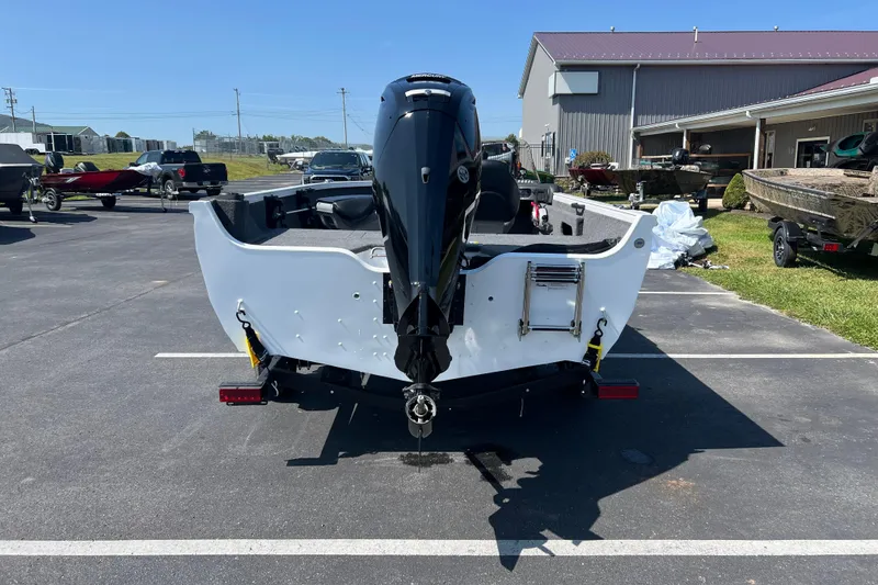Slide: The Image of 2024 Crestliner 1650 HAWK SC boat, rear view with outboard motor, parked outdoors. - 2