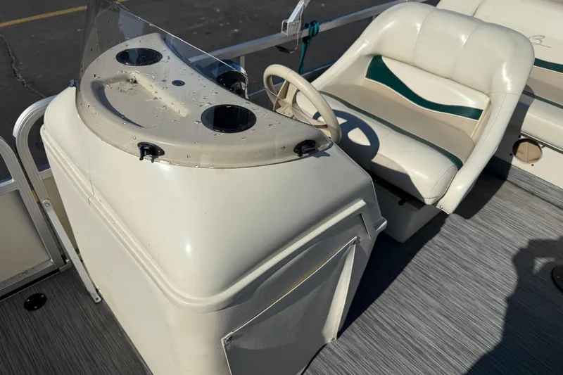 Slide: The Image of 1999 Bennington 208 L boat interior with steering console and cushioned seat. - 12