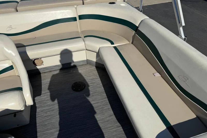 Slide: The Image of Interior of a 1999 Bennington 208 L boat with beige and green seating. - 13