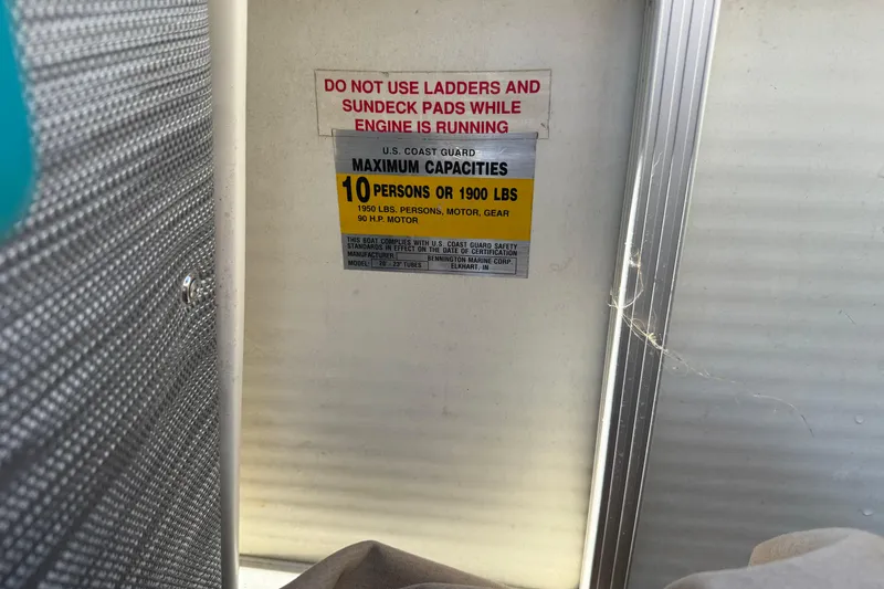 Slide: The Image of Warning label on 1999 Bennington 208 L boat, showing maximum capacity and safety instructions. - 17