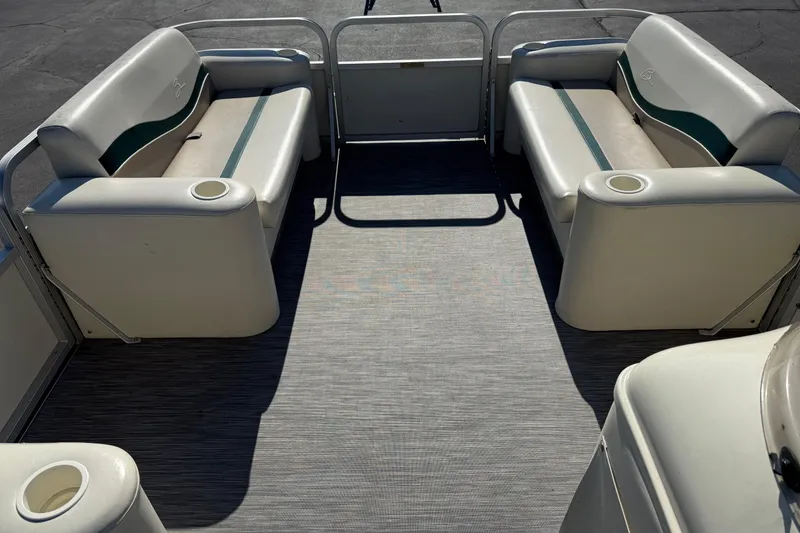 Slide: The Image of 1999 Bennington 208 L pontoon boat interior with cushioned seating and cup holders. - 18