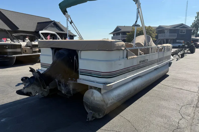 Slide: The Image of 1999 Bennington 208 L pontoon boat parked on a driveway, rear view. - 4