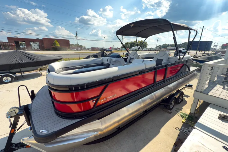 The Image of 2024 Godfrey Sweetwater 22' pontoon boat with red exterior and split bench seating. - 1