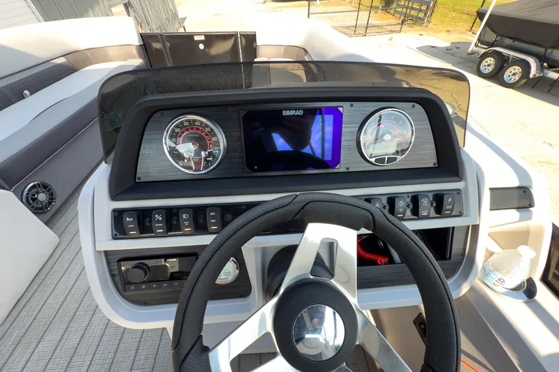 Slide: The Image of 2024 Godfrey Sweetwater 22' boat dashboard with steering wheel and control panel. - 10