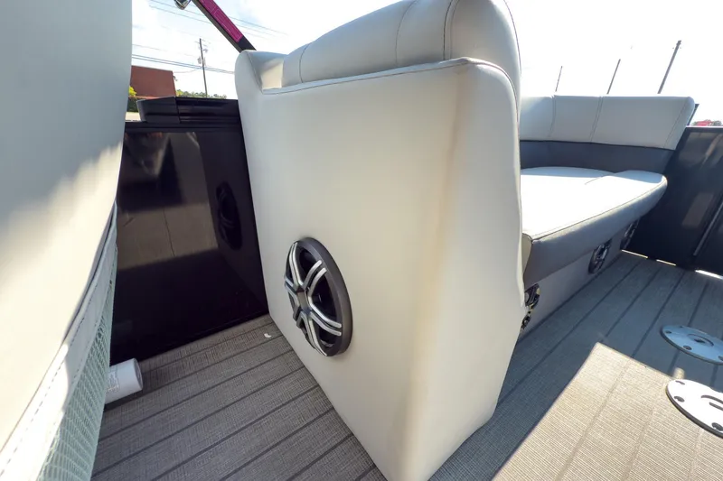 Slide: The Image of 2024 Godfrey Sweetwater 22' Split Bench interior with speaker, showcasing luxury seating and flooring. - 14