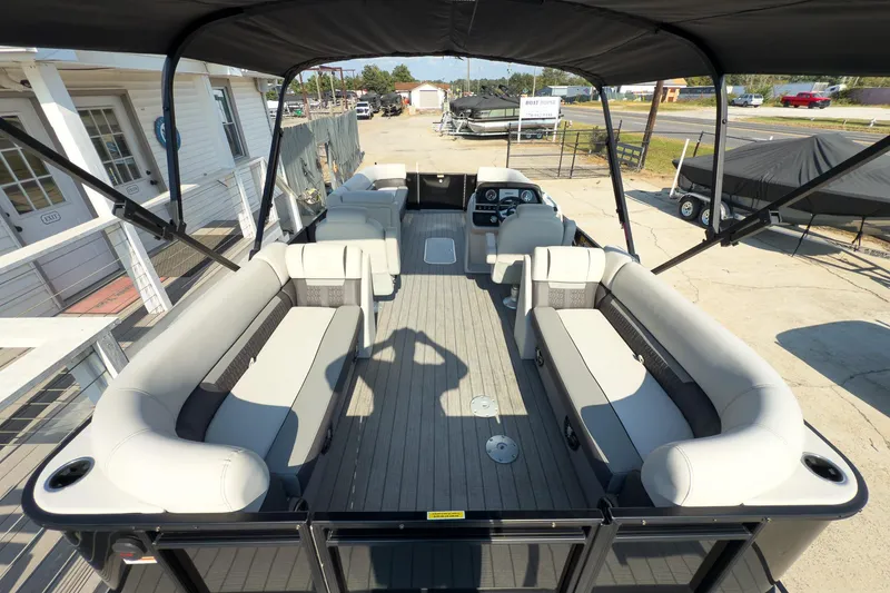 Slide: The Image of 2024 Godfrey Sweetwater 22' pontoon boat with spacious seating and canopy, docked outdoors. - 18