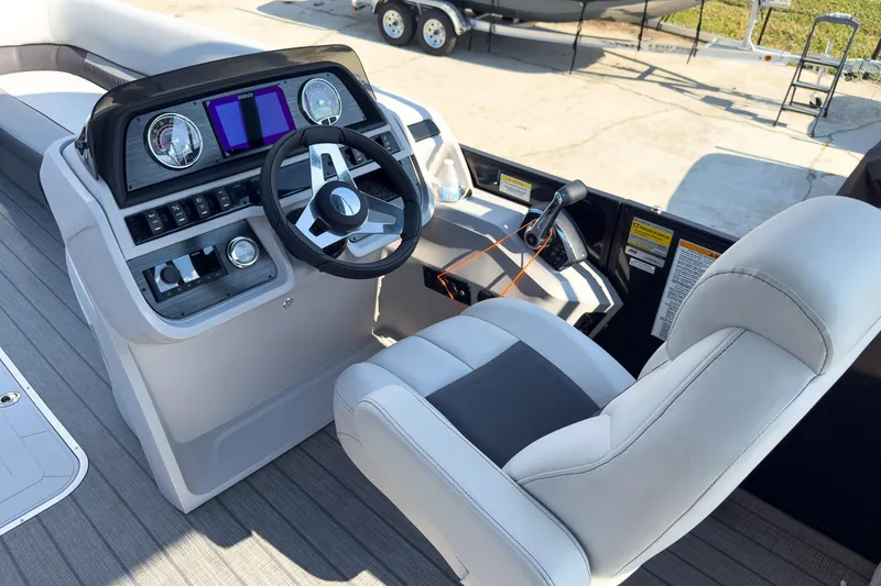 Slide: The Image of 2024 Godfrey Sweetwater 22' boat helm with modern controls and comfortable seating. - 9