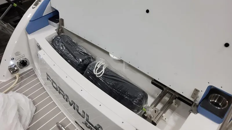 Slide: The Image of 2025 Formula 330 Crossover Bowrider OB storage compartment with wrapped items inside. - 17