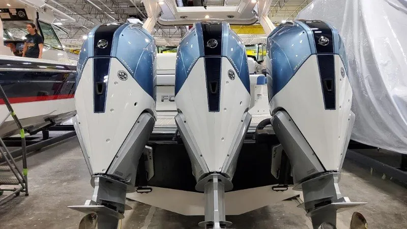 Slide: The Image of 2025 Formula 330 Crossover Bowrider OB with triple outboard engines in a showroom. - 23