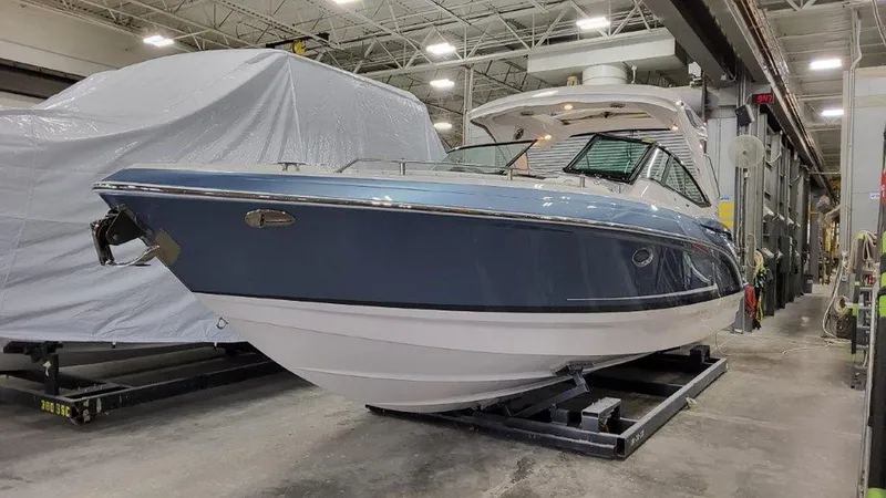 Slide: The Image of 2025 Formula 330 Crossover Bowrider OB in a showroom, blue hull, sleek design. - 27