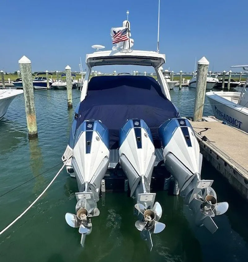 Slide: The Image of 2025 Formula 330 Crossover Bowrider OB with triple outboard engines docked in marina. - 31