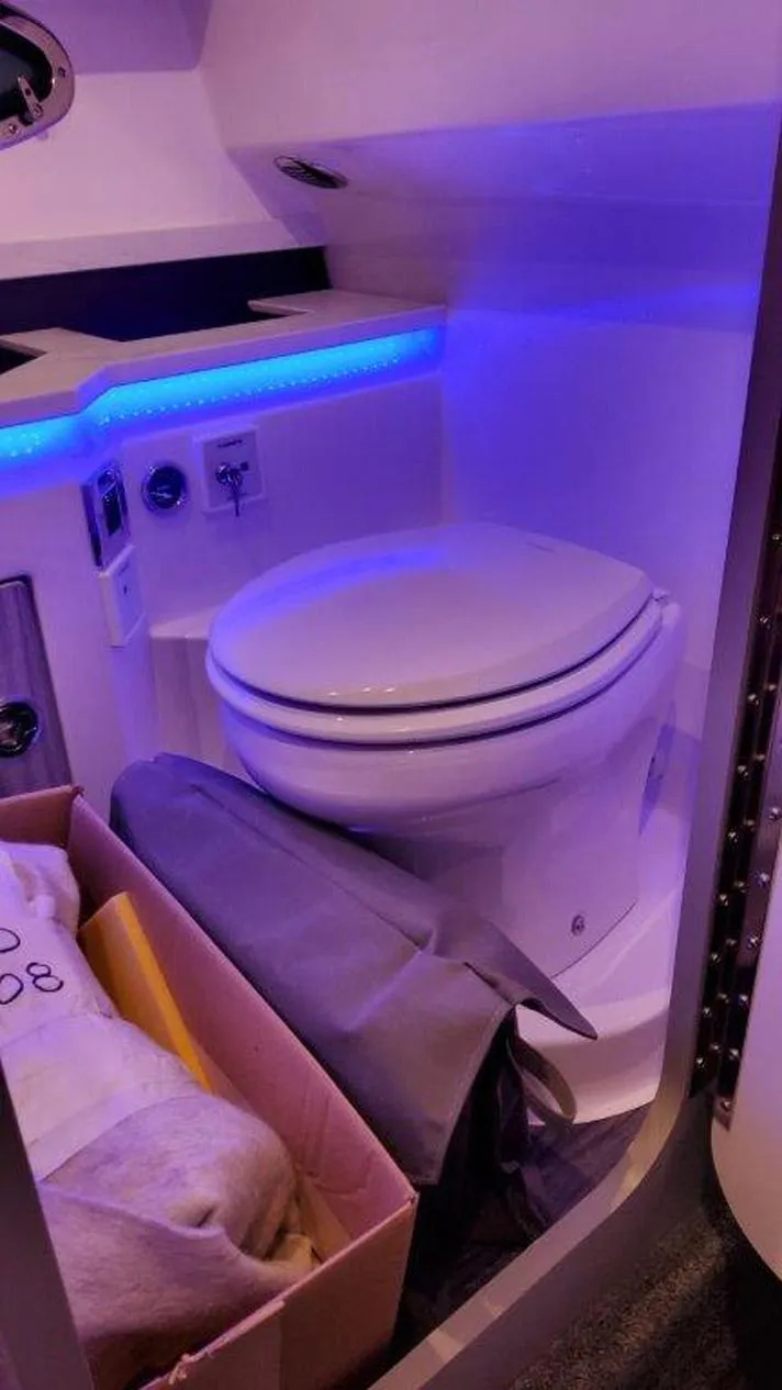 Slide: The Image of 2025 Formula 330 Crossover Bowrider OB boat interior with modern toilet and ambient lighting. - 8