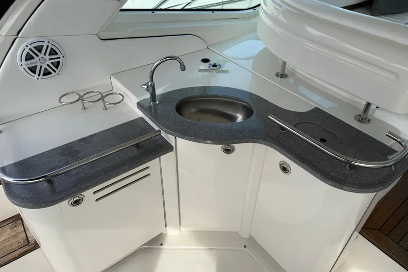 Slide: The Image of 2006 Sea Ray 48 Sundancer yacht kitchenette with sink, countertop, and speaker. - 14
