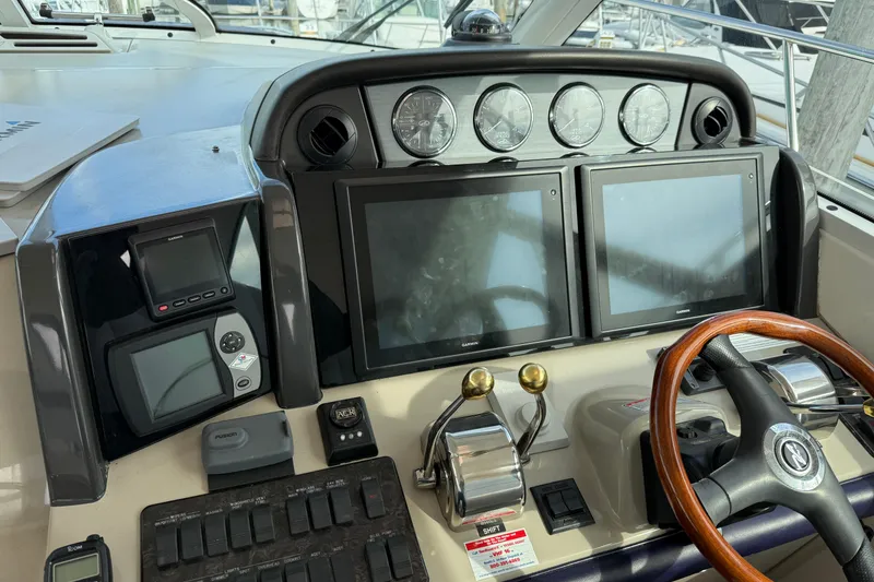 Slide: The Image of Helm of 2006 Sea Ray 48 Sundancer with dual screens and wooden steering wheel. - 29