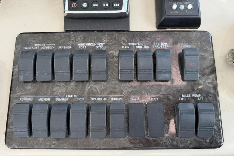 Slide: The Image of Control panel of a 2006 Sea Ray 48 Sundancer boat with various switches. - 41