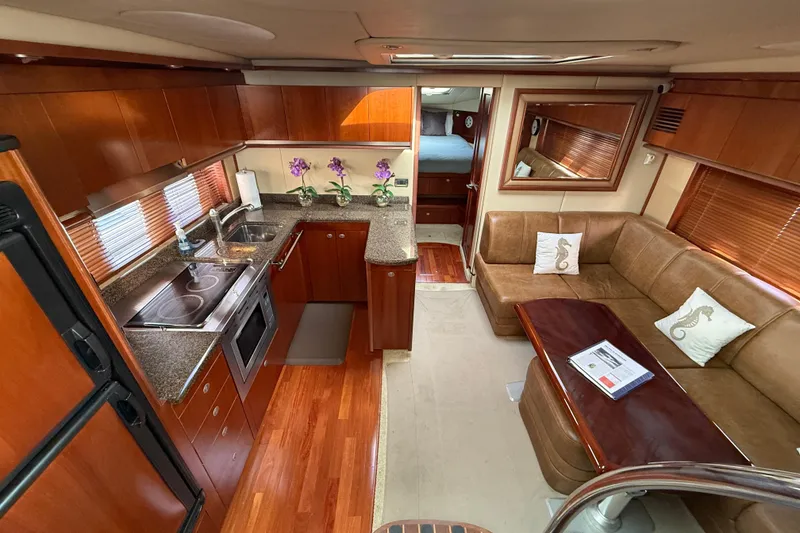 Slide: The Image of Luxurious 2006 Sea Ray 48 Sundancer yacht interior with kitchen and seating area. - 48