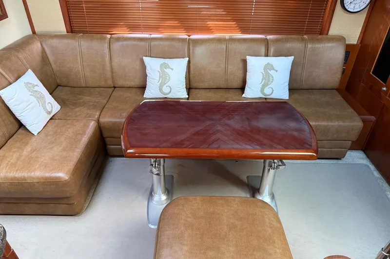 Slide: The Image of Luxurious 2006 Sea Ray 48 Sundancer interior with leather seating and elegant wooden table. - 52