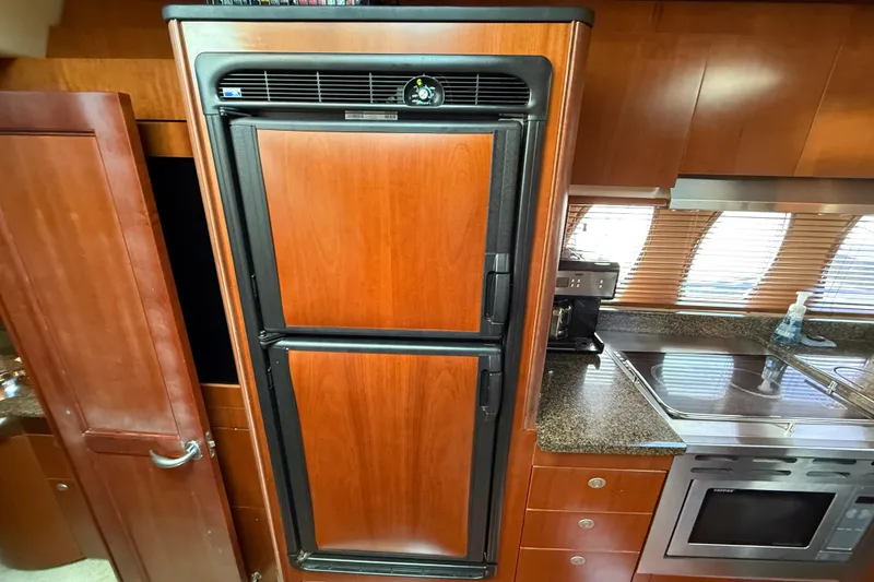 Slide: The Image of Luxury kitchen interior of 2006 Sea Ray 48 Sundancer yacht with wood cabinetry and modern appliances. - 59