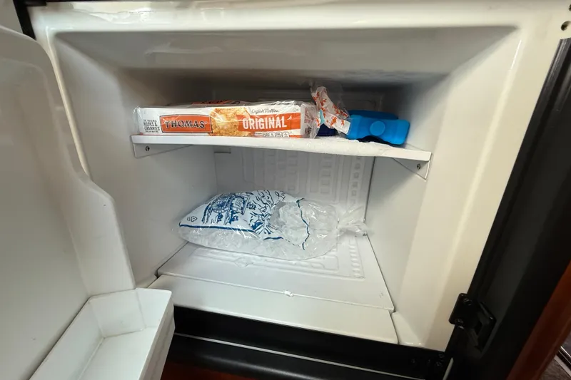 Slide: The Image of Freezer with ice bag, English muffins, and ice packs on a 2006 Sea Ray 48 Sundancer. - 60