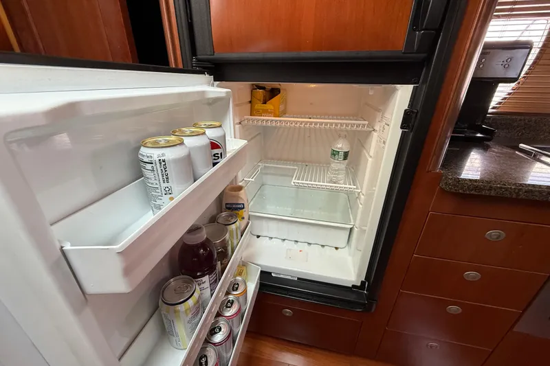 Slide: The Image of Mini fridge inside 2006 Sea Ray 48 Sundancer yacht, stocked with drinks and condiments. - 61