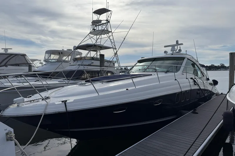 Slide: The Image of 2006 Sea Ray 48 Sundancer yacht docked at marina under cloudy sky. - 7