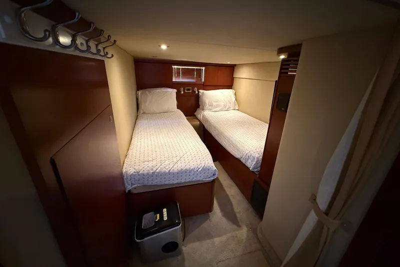 Slide: The Image of Interior cabin of 2006 Sea Ray 48 Sundancer with twin beds and wooden finish. - 81