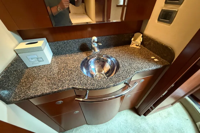 Slide: The Image of 2006 Sea Ray 48 Sundancer bathroom with granite countertop and stainless steel sink. - 83