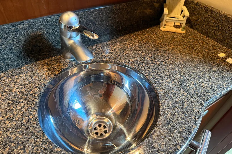 Slide: The Image of Granite countertop with a sleek metal sink and faucet on a 2006 Sea Ray 48 Sundancer. - 84