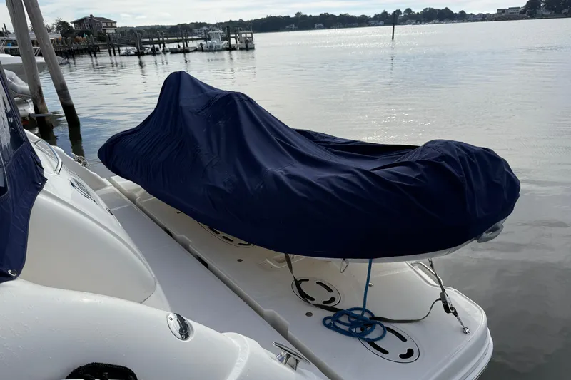 Slide: The Image of 2006 Sea Ray 48 Sundancer with covered equipment on deck, docked by calm waters. - 9