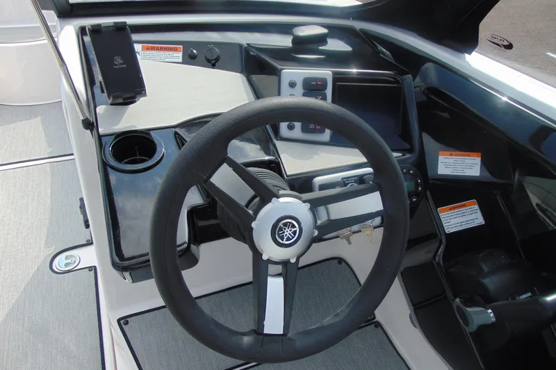 Slide: The Image of 2026 Yamaha AR220 boat dashboard with steering wheel, controls, and warning labels. - 17